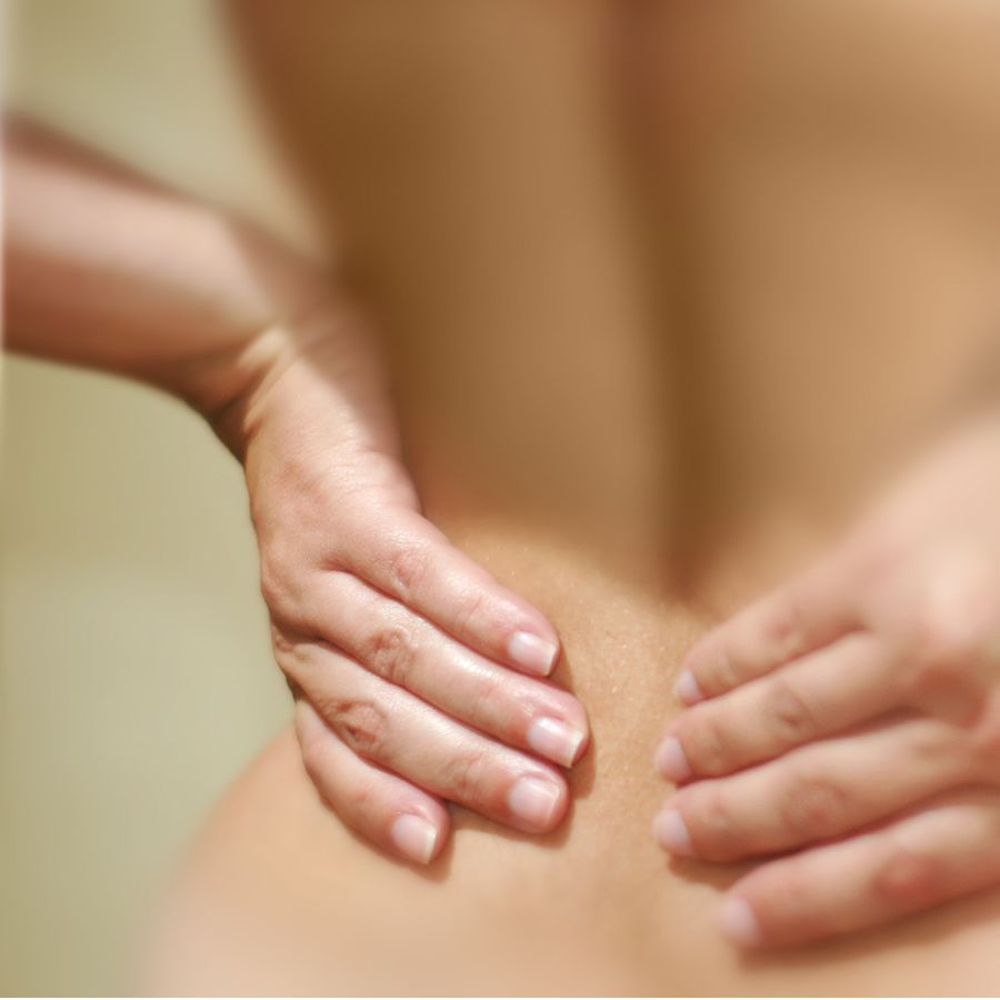 Closeup of two hands clutching lower back sciatic pain